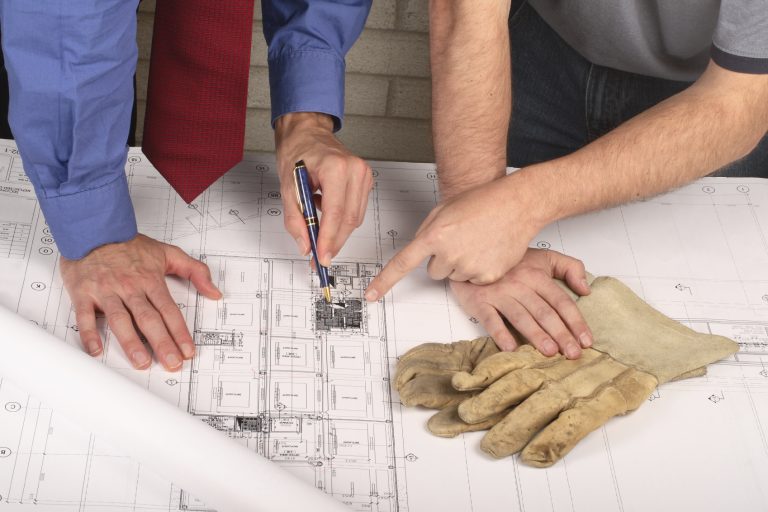 Full & Partial Rewire Planning – VoltFix Electrical Ltd Technical drawings on table with two people reviewing wiring layout – full and partial rewire planning in Andover