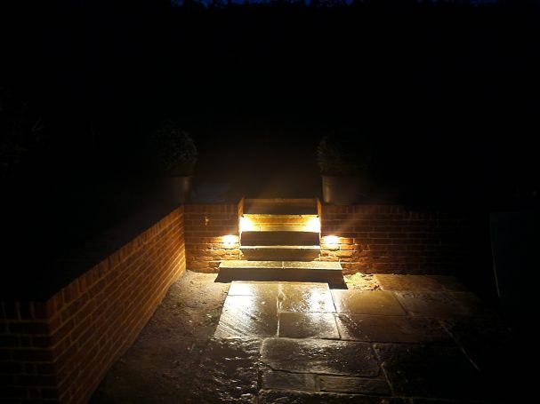 Cosy lit stairs leading up to a garden.