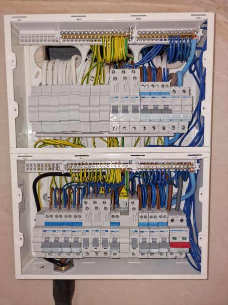 Close-up of an electrical distribution board with multiple circuit breakers and wiring.